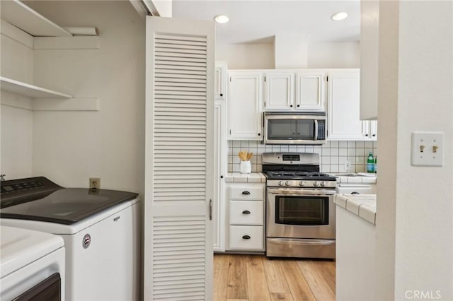 1304 12th St Unit B, Manhattan Beach, CA 90266 - kitchen with tile counters, stainless steel appliances, washer and clothes dryer, white cabinets, and decorative backsplash