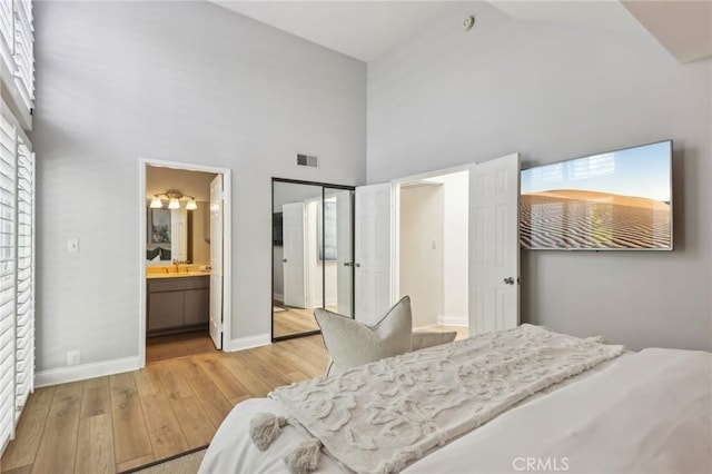 1304 12th St Unit B, Manhattan Beach, CA 90266 - bedroom featuring high vaulted ceiling, wood finished floors, baseboards, a sink, and ensuite bath