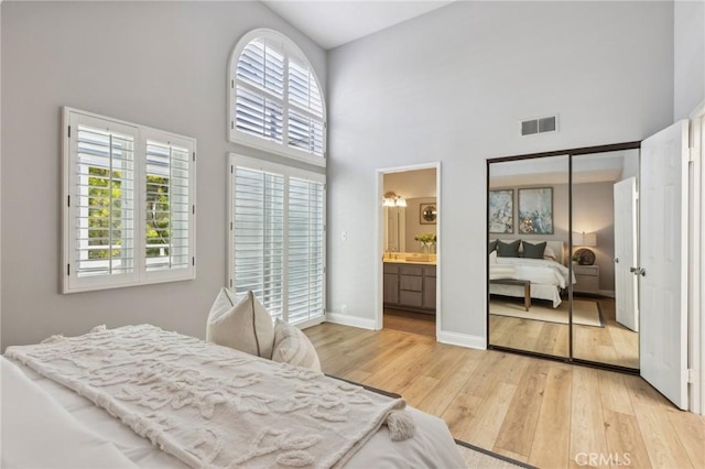 1304 12th St Unit B, Manhattan Beach, CA 90266 - bedroom featuring a towering ceiling, multiple windows, light wood-style floors, baseboards, and ensuite bath