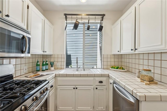 1304 12th St Unit B, Manhattan Beach, CA 90266 - kitchen with stainless steel appliances, white cabinetry, a sink, and tile countertops