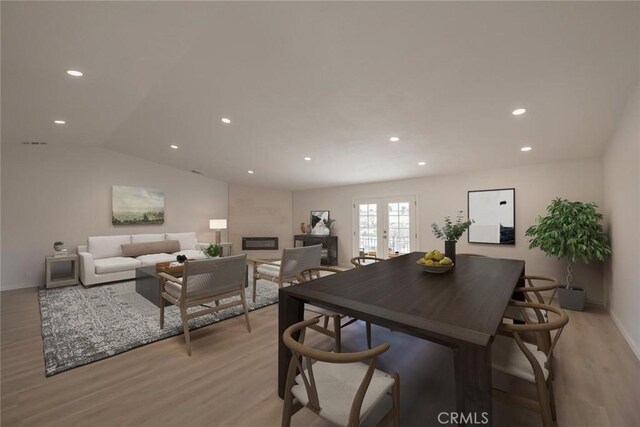 16739 Mission St, Hesperia, CA 92345 - dining room with light wood-style flooring, french doors, a glass covered fireplace, recessed lighting, and vaulted ceiling