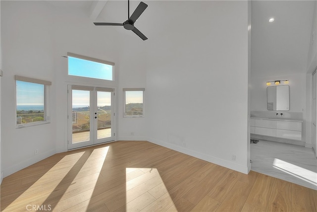 27 Burriana, San Clemente, CA 92672 - unfurnished living room with high vaulted ceiling, a ceiling fan, baseboards, light wood-style flooring, and french doors