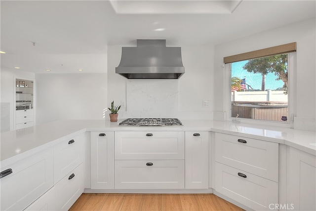 27 Burriana, San Clemente, CA 92672 - kitchen featuring wall chimney exhaust hood, light countertops, recessed lighting, white cabinetry, and stainless steel gas cooktop