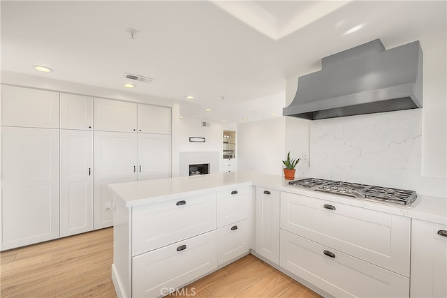 27 Burriana, San Clemente, CA 92672 - kitchen featuring wall chimney exhaust hood, light countertops, white cabinets, light wood-style floors, and recessed lighting