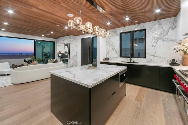 5007 Seashore Dr, Newport Beach, CA 92663 - kitchen with a sink, high end stainless steel range oven, a kitchen island, decorative light fixtures, and glass insert cabinets