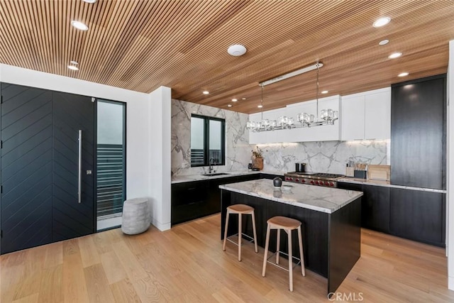 5007 Seashore Dr, Newport Beach, CA 92663 - kitchen with a kitchen island, a kitchen bar, white cabinets, decorative light fixtures, and wooden ceiling
