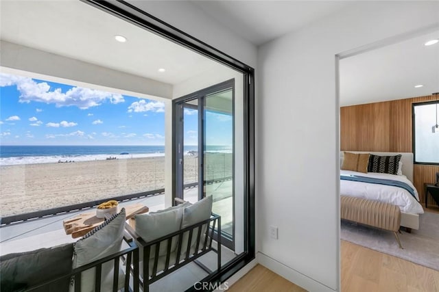 5007 Seashore Dr, Newport Beach, CA 92663 - bedroom featuring light wood-type flooring, access to outside, view of water and beach, recessed lighting, and wood walls