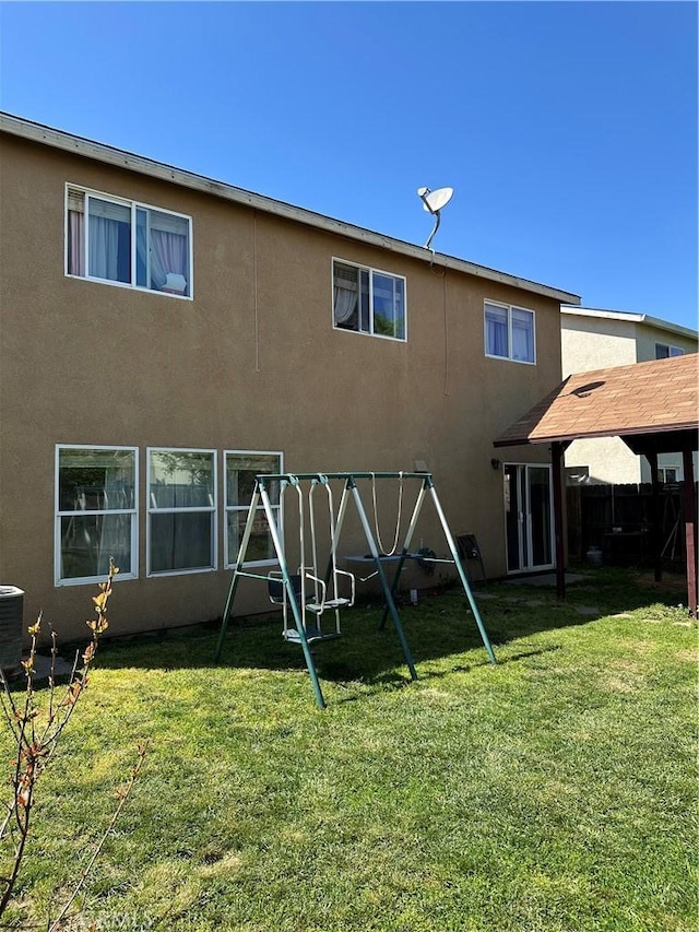 336 Pyramid Ave, Merced, CA 95341 - back of house with a playground, stucco siding, and central AC
