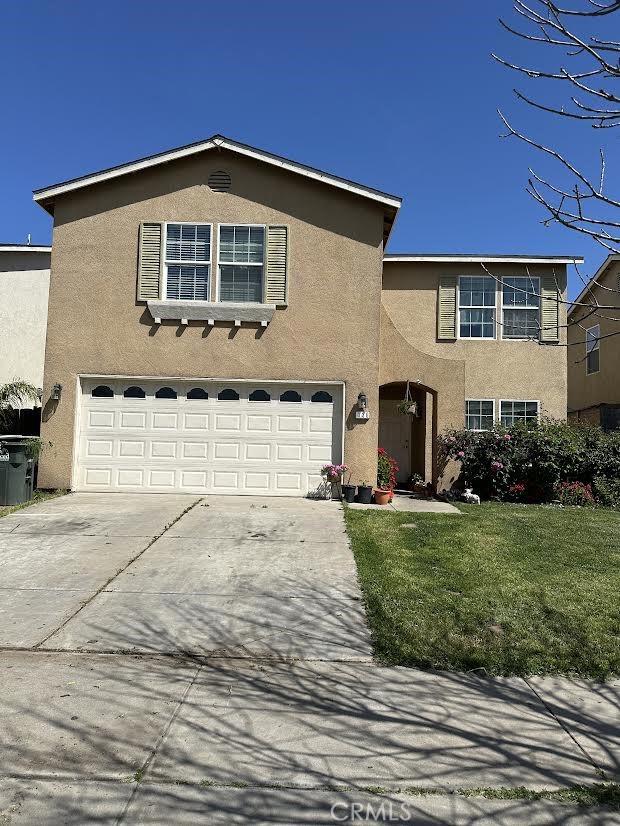 336 Pyramid Ave, Merced, CA 95341 - traditional-style home featuring an attached garage, concrete driveway, stucco siding, and a front lawn