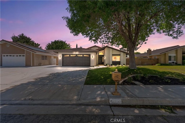 view of front facade with a garage, driveway, and stucco siding