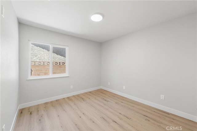 spare room with wood finished floors and baseboards