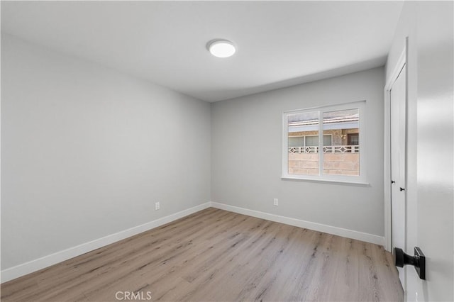 unfurnished bedroom with light wood-style floors, baseboards, and a closet