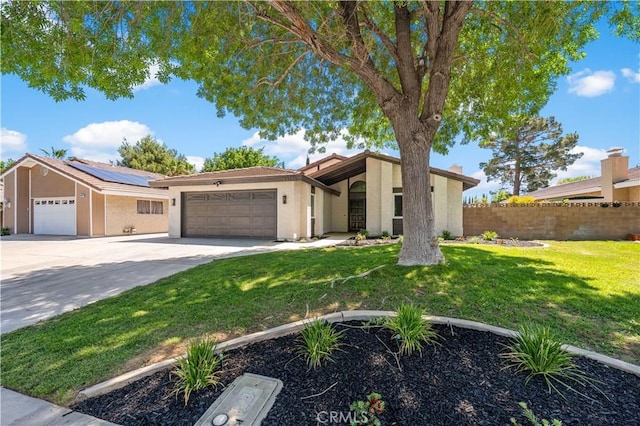 view of front of property featuring a garage, concrete driveway, stucco siding, and roof mounted solar panels