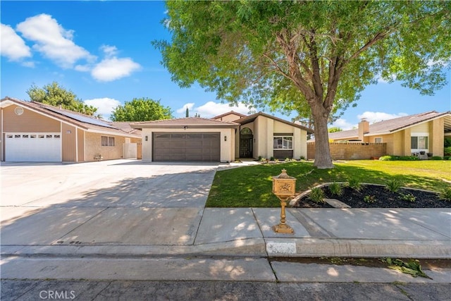 view of front of home with an attached garage, concrete driveway, stucco siding, and solar panels
