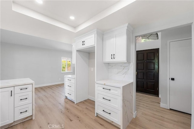 kitchen featuring light wood-style flooring, white cabinets, backsplash, light stone counters, and recessed lighting