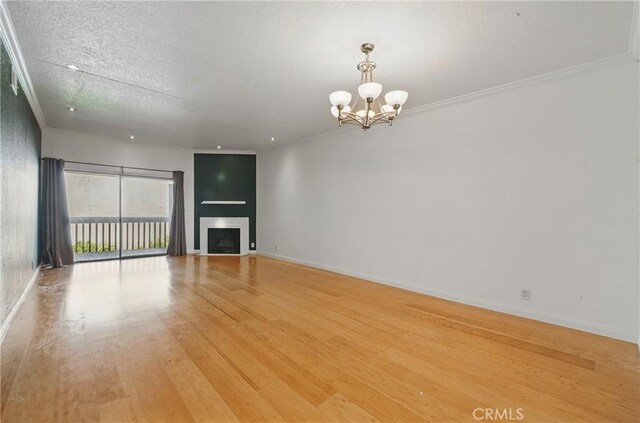 2101 E 21st St Unit 310, Signal Hill, CA 90755 - unfurnished living room with light wood-type flooring, a chandelier, a fireplace, baseboards, and a textured ceiling