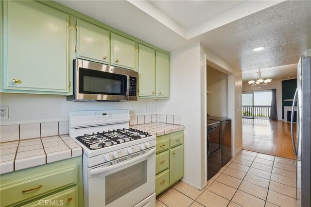 2101 E 21st St Unit 310, Signal Hill, CA 90755 - kitchen featuring appliances with stainless steel finishes, washer and dryer, green cabinets, and tile countertops