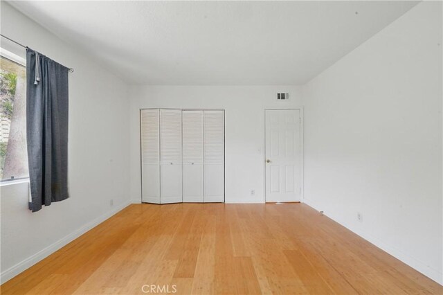 2101 E 21st St Unit 310, Signal Hill, CA 90755 - unfurnished bedroom with light wood-style flooring, a closet, and baseboards