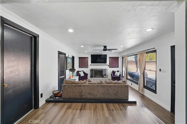 9489 Muroc St, Bellflower, CA 90706 - living room with wood finished floors, ceiling fan, a fireplace with raised hearth, recessed lighting, and crown molding