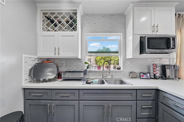 9489 Muroc St, Bellflower, CA 90706 - kitchen with stainless steel microwave, gray cabinets, a sink, light countertops, and tasteful backsplash