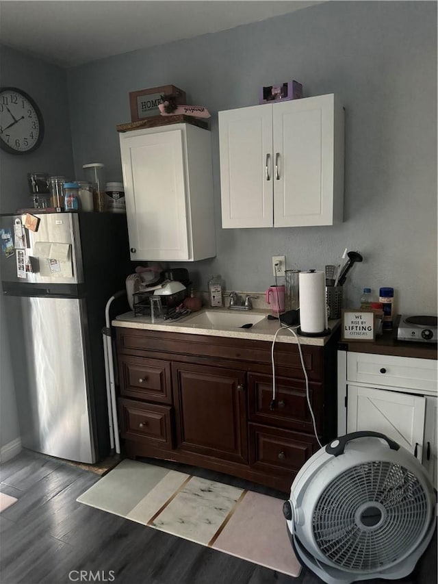 9489 Muroc St, Bellflower, CA 90706 - kitchen featuring freestanding refrigerator, a sink, light wood-style floors, white cabinets, and light countertops