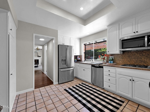 kitchen with appliances with stainless steel finishes, tasteful backsplash, white cabinetry, dark countertops, and recessed lighting