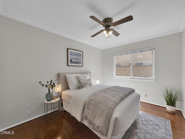 bedroom featuring wood finished floors, baseboards, crown molding, and a ceiling fan
