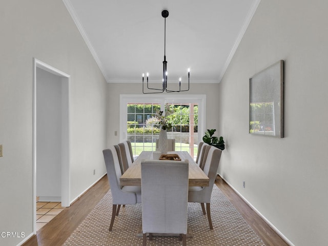dining room featuring wood finished floors, a chandelier, crown molding, and baseboards