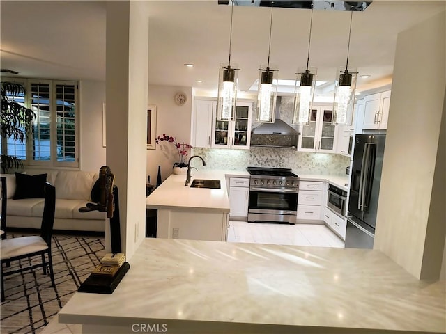 6 Whittier Ct, Rancho Mirage, CA 92270 - kitchen featuring stainless steel appliances, a sink, a peninsula, decorative backsplash, and glass insert cabinets