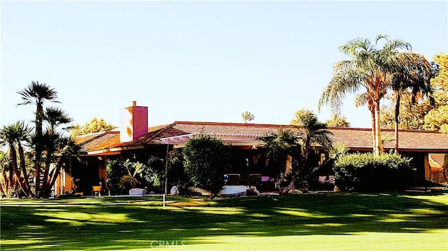 6 Whittier Ct, Rancho Mirage, CA 92270 - back of house with a lawn and a chimney