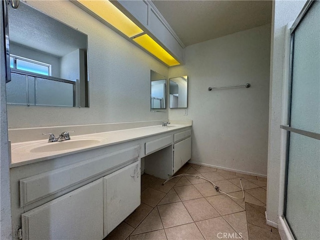 full bathroom with a shower stall, double vanity, tile patterned floors, and baseboards