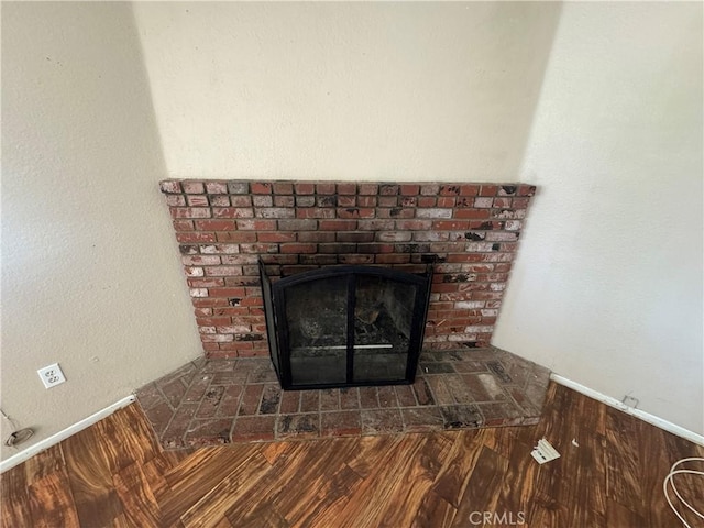 detailed view of a brick fireplace and wood finished floors
