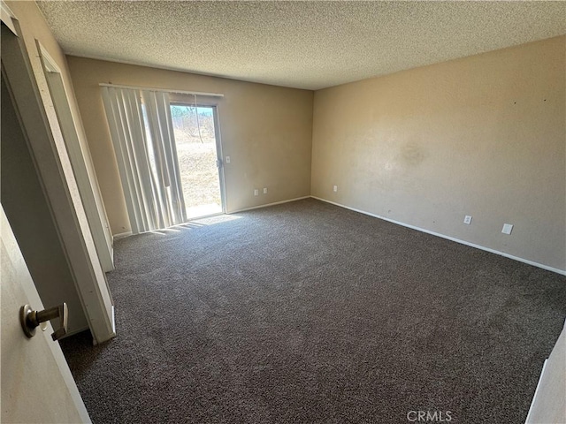 unfurnished room with dark carpet, a textured ceiling, and baseboards