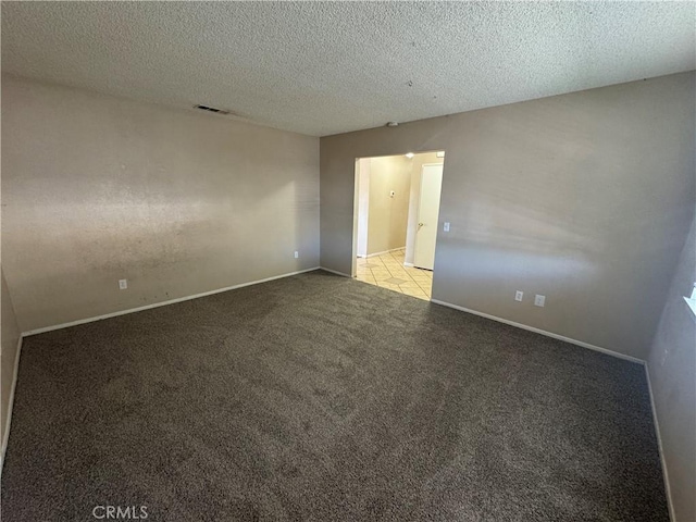 spare room featuring carpet floors, baseboards, and a textured ceiling