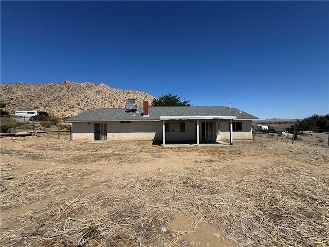 back of house with a mountain view, a patio, and fence