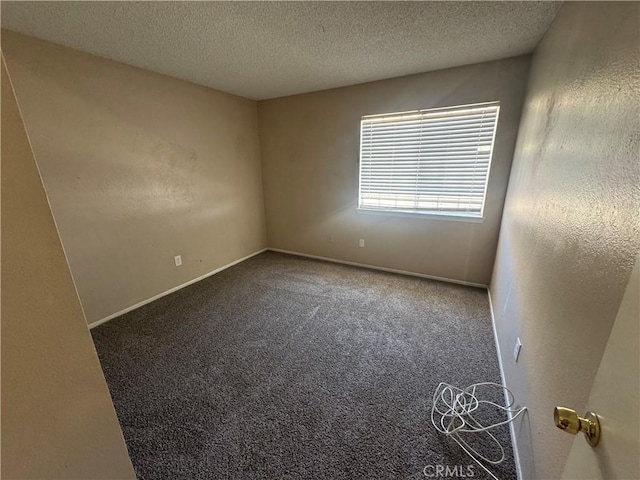 spare room featuring carpet floors, baseboards, and a textured ceiling