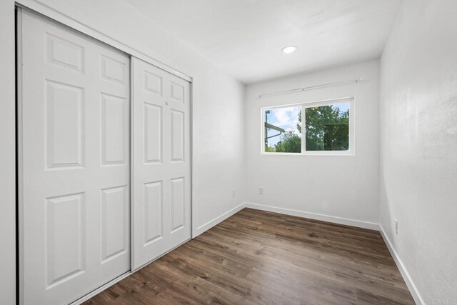 4585 Mount Henry Pl, San Diego, CA 92117 - unfurnished bedroom with dark wood-style floors, a closet, and baseboards