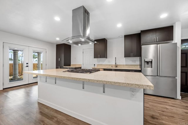 4585 Mount Henry Pl, San Diego, CA 92117 - kitchen featuring appliances with stainless steel finishes, island exhaust hood, a large island, wood finished floors, and recessed lighting