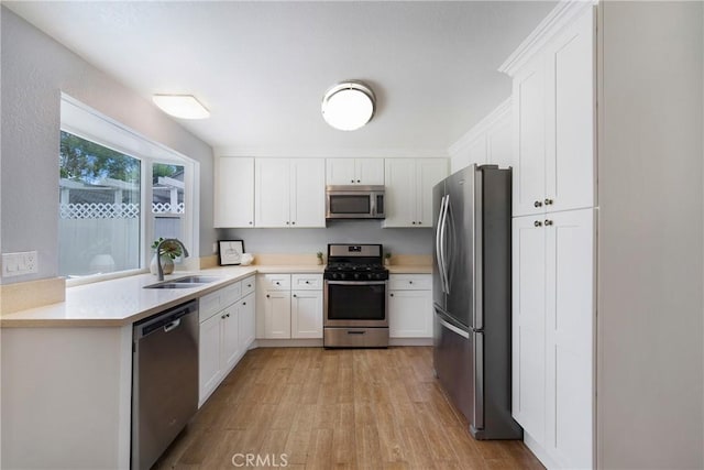 22986 Caminito Regalo Unit 92, Laguna Hills, CA 92653 - kitchen with stainless steel appliances, a sink, light wood finished floors, white cabinets, and light countertops
