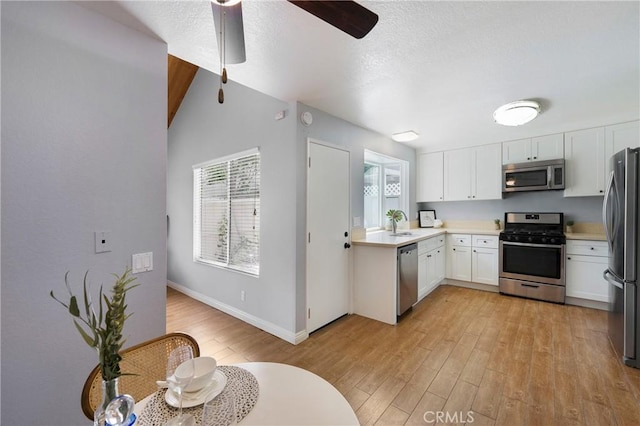 22986 Caminito Regalo Unit 92, Laguna Hills, CA 92653 - kitchen with appliances with stainless steel finishes, ceiling fan, light wood finished floors, white cabinets, and light countertops
