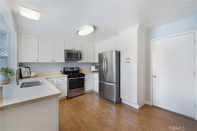 22986 Caminito Regalo Unit 92, Laguna Hills, CA 92653 - kitchen featuring appliances with stainless steel finishes, a sink, light countertops, light wood-style floors, and white cabinets