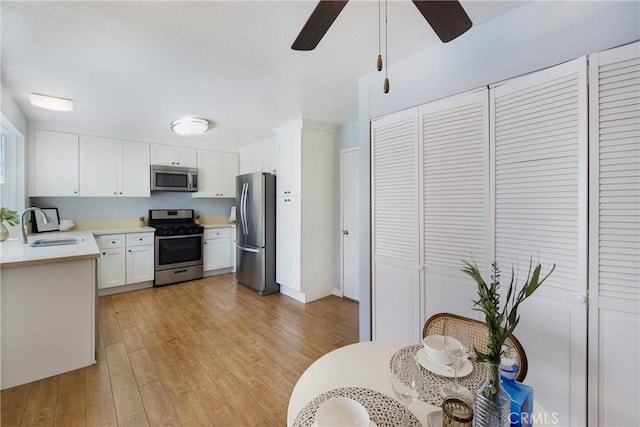 22986 Caminito Regalo Unit 92, Laguna Hills, CA 92653 - kitchen with stainless steel appliances, a sink, ceiling fan, light countertops, and light wood-style flooring