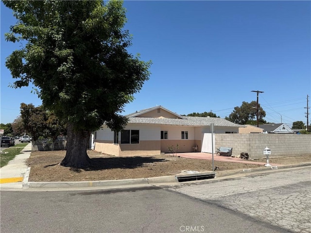 view of front of house with fence and stucco siding