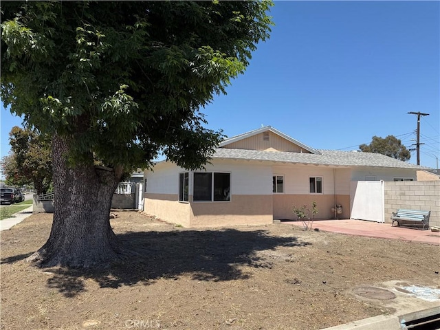 rear view of property featuring a patio area and fence