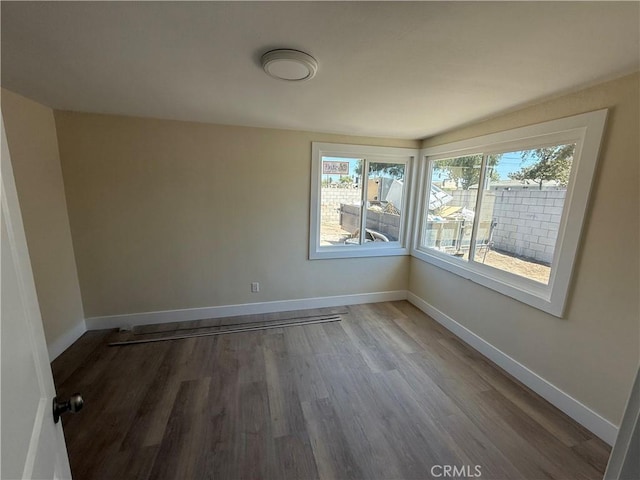 unfurnished room featuring wood finished floors and baseboards