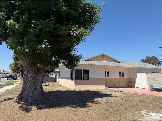 view of side of property with fence and a patio