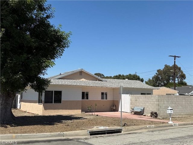 view of side of property with fence, a patio, and stucco siding