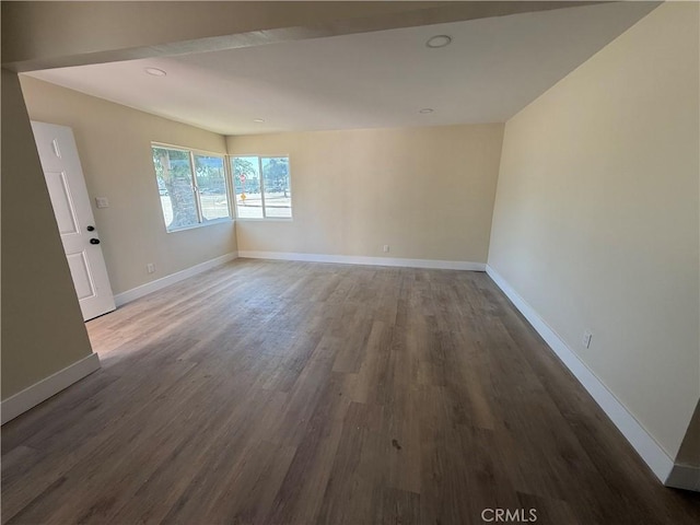 empty room featuring wood finished floors, baseboards, and recessed lighting