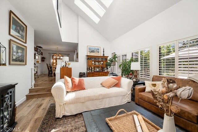 1762 Southfork Pl, Paso Robles, CA 93446 - living area featuring a skylight, wood finished floors, high vaulted ceiling, a chandelier, and baseboards