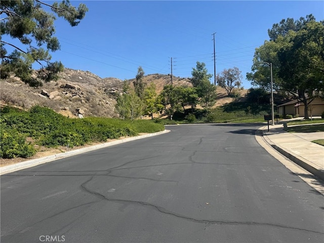 512 Via Ln, Paloma, Riverside, CA 92507 - view of asphalt road with curbs, street lights, sidewalks, and a mountain view